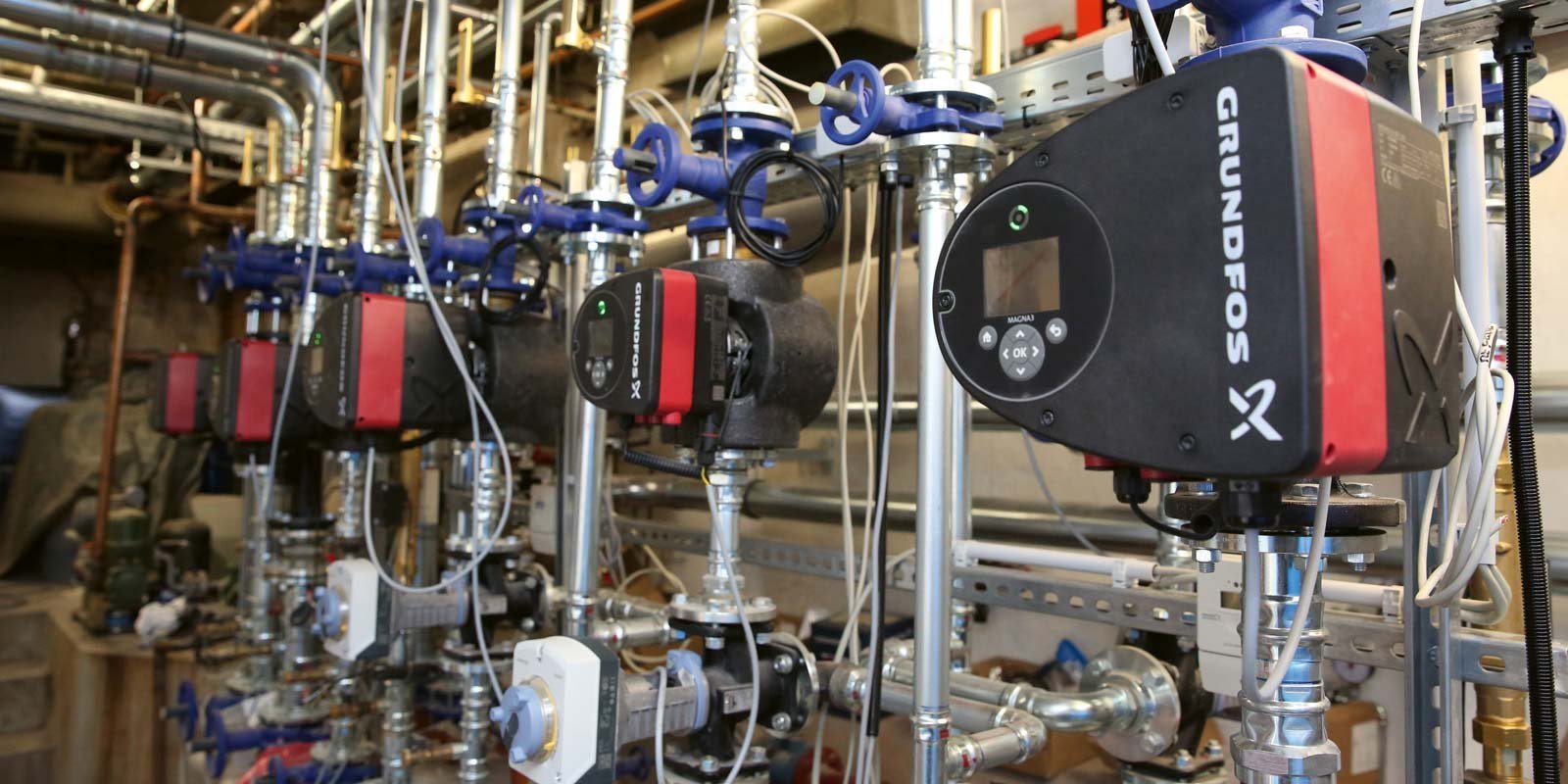 Mehrere Grundfos-Pumpen sind an einem Metallgestell montiert, um eine effiziente Wasserverteilung zu gewährleisten.